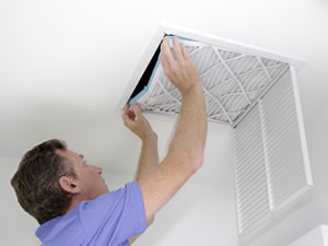 Male installing a filter in the ventilation duct